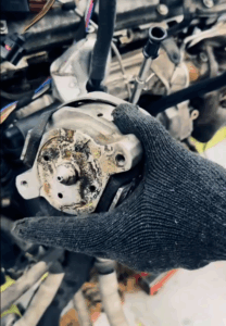 Mechanic tightening bolts on Bentley Continental engine mount after replacement