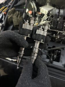Close-up of removed fuel injectors during Rolls-Royce Ghost fuel injector replacement service at The Car Lab Auto Repair Center Dubai.