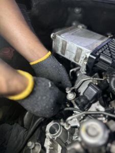 Technician installing new fuel injectors on a Rolls-Royce Ghost engine in Dubai workshop.