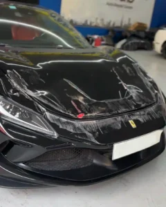 Ferrari 296 GTB accident-damaged bonnet awaiting repair and repaint at Dubai workshop